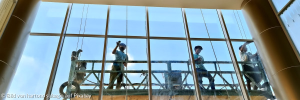 Mitarbeiter durch ein Fenster betrachtet